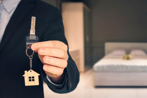manager handing keys to tenant with renters insurance