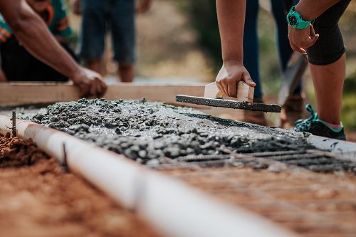 builders pouring and smoothing cement